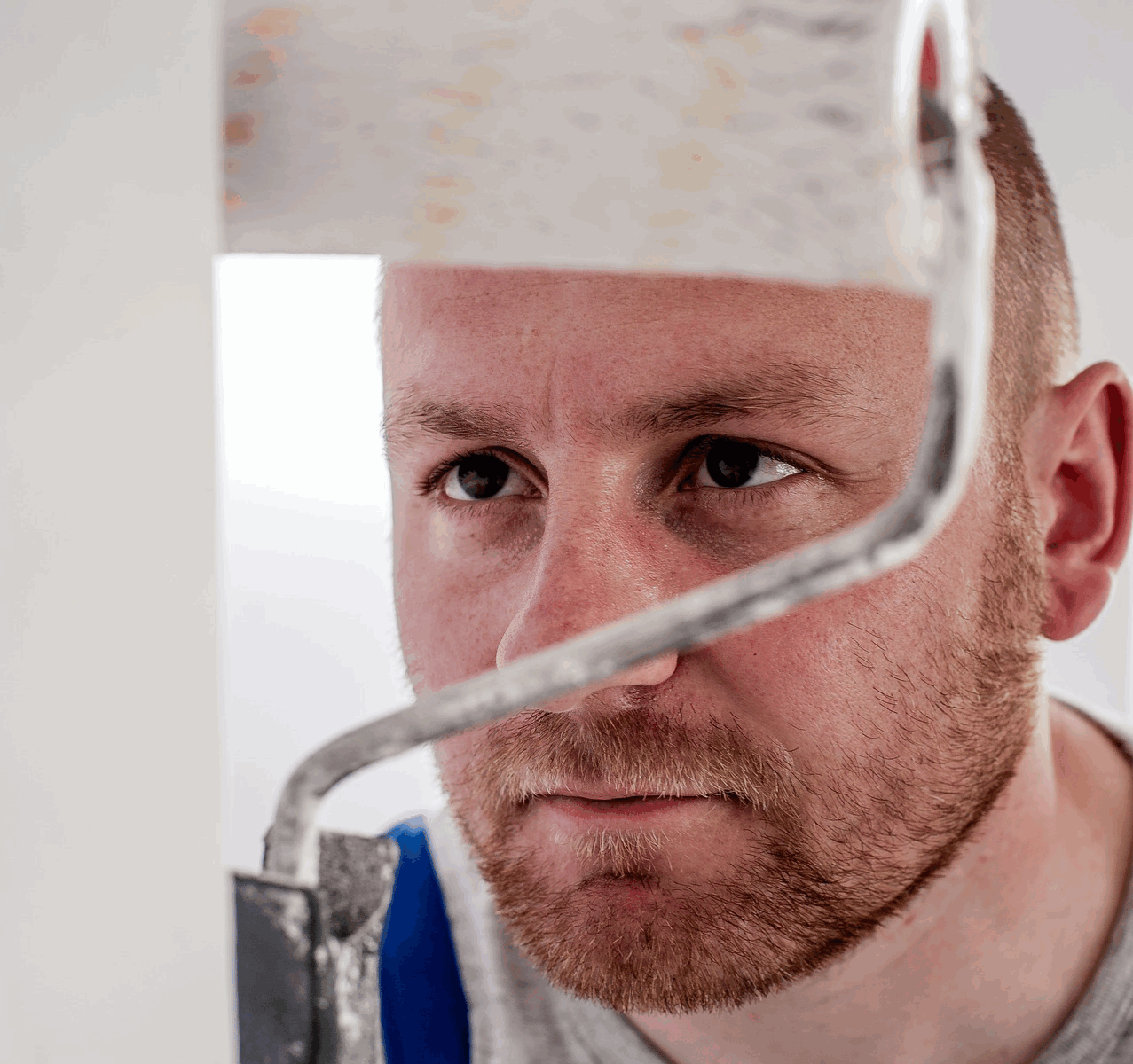 Using a paint roller on a ladder